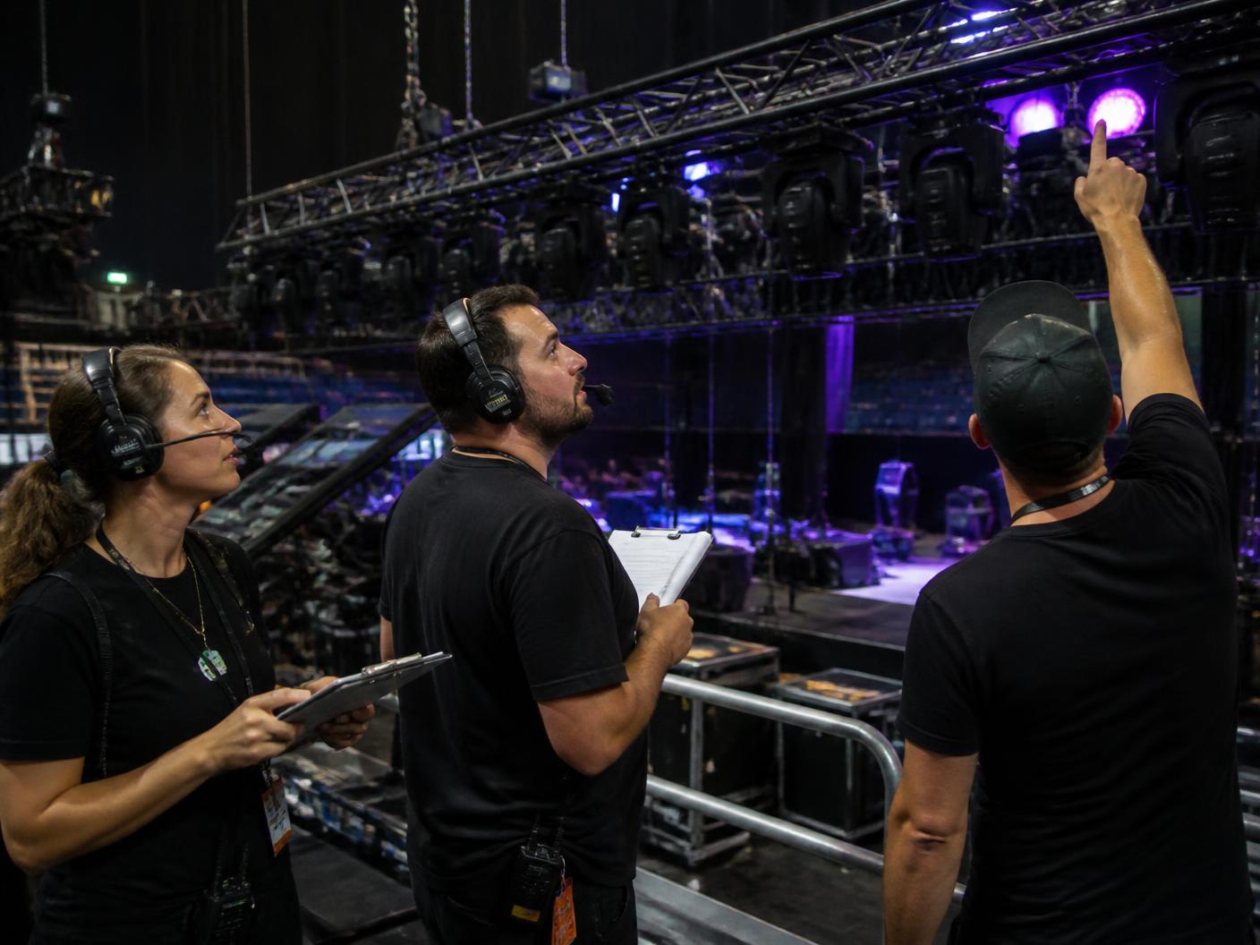 Events EV production crew checking a lighting rig backstage before a concert