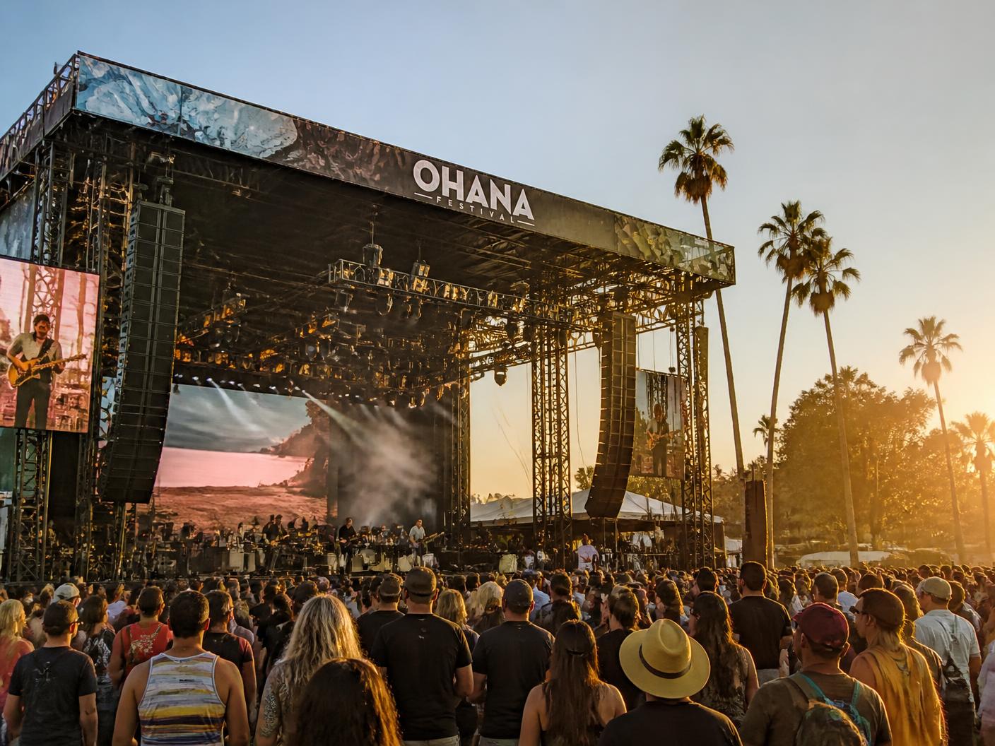 Festival main stage at golden hour with a full crowd